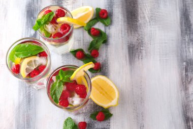 Ahşap masa üzerinde taze ahududu mojito bardak
