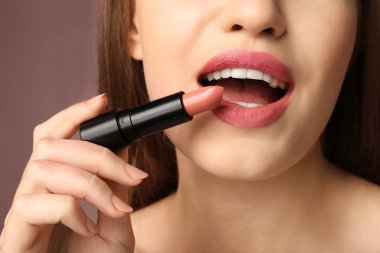 Pembe ruj rengi arka planda, closeup uygulama güzel genç kadın