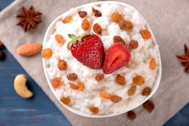 Lezzetli pirinç puding, Kuru üzüm ve çilekli peçete üzerinde kase