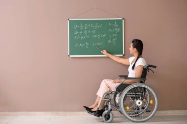 Kadın öğretmen okulda yakınındaki tekerlekli sandalyede
