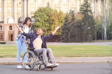 Tekerlekli sandalye ve eşi açık havada Genç adam