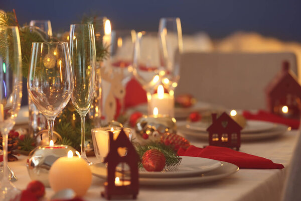 Stylish table setting with burning candles and Christmas decorations