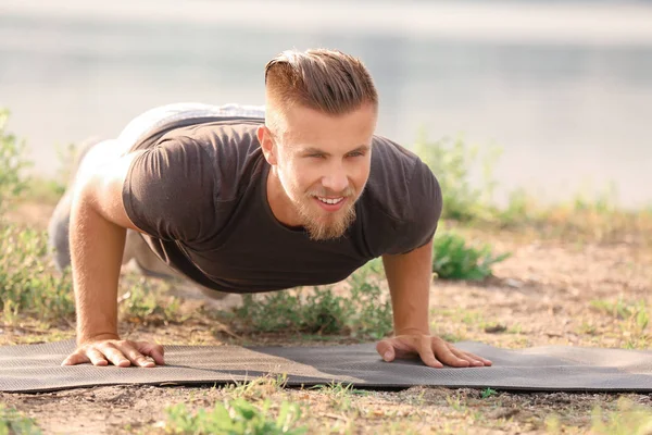 Sportif genç adam dışarıda antrenman yapıyor.