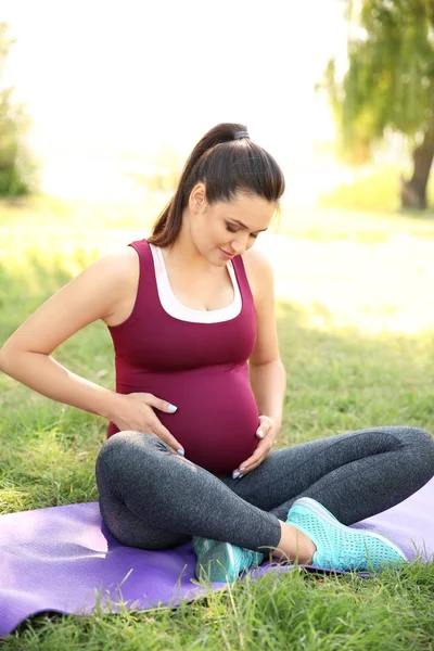 Yoga Mat Açık Havada Oturan Genç Hamile Kadın — Stok fotoğraf