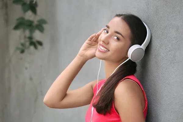 Beautiful Young Woman Listening Music Grey Wall Outdoors — Stock Photo, Image