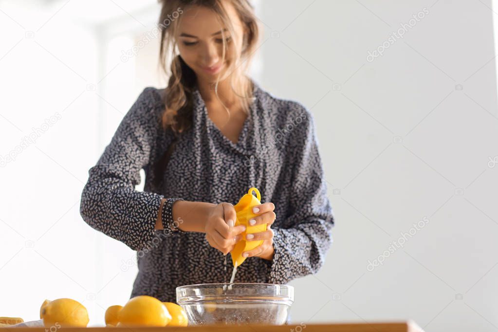 Young woman preparing fresh lemonade at home