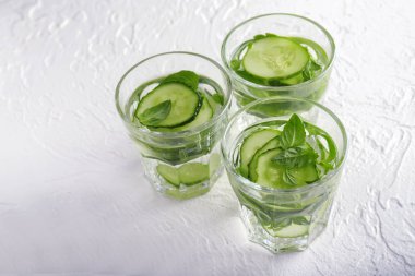 Salatalık bardak su beyaz dokulu arka plan üzerinde infüzyon