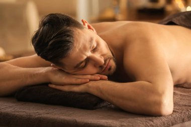 Genç adam rahatlatıcı spa salonu Masaj tablo