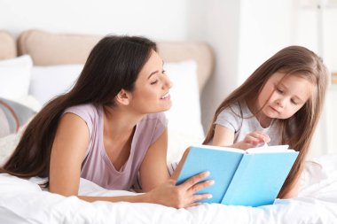 Anne ve kızı evde birlikte kitap okuma
