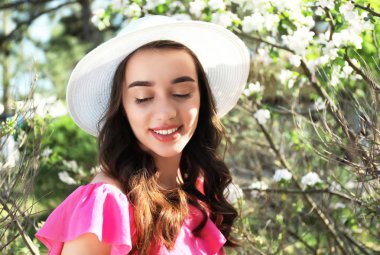 Güneşli bahar gününde çiçek açması tree yakınındaki güzel genç kadın