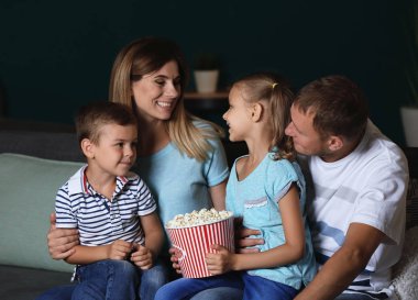 Mutlu aile akşam Tv izlerken patlamış mısır yemek