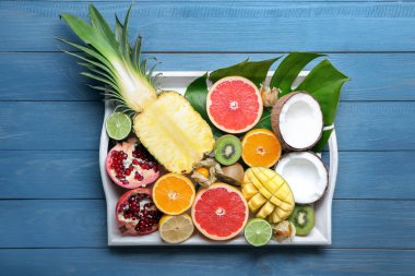 Ahşap masa üzerinde çeşitli lezzetli egzotik meyve ile tepsi