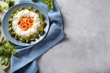 Haşlanmış pirinç, brokoli ve gri arka plan üzerinde karides ile plaka