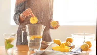 Genç kadın, evde taze limonata hazırlanıyor