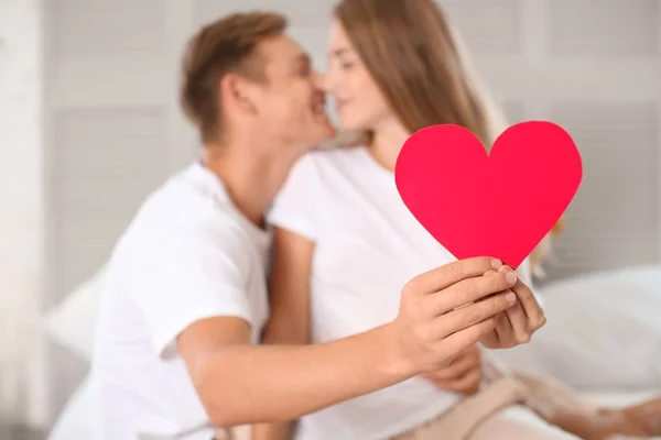 Feliz Pareja Joven Con Corazón Rojo Sentado Cama Casa — Foto de Stock