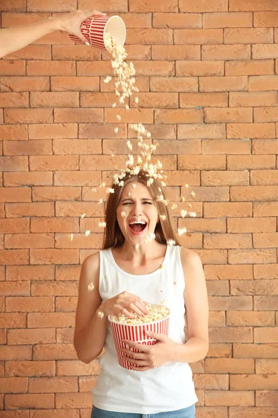 Popcorn Fällt Auf Schöne Junge Frau Gegen Ziegelmauer — Stockfoto