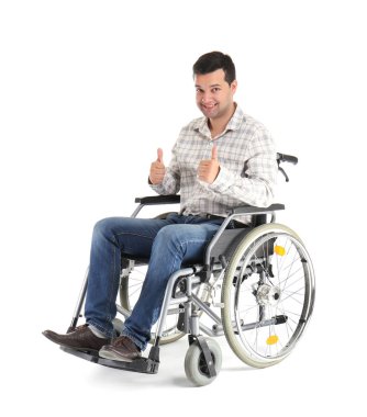 Başparmak-up jest beyaz arka plan üzerinde gösterilen tekerlekli sandalyede genç adam
