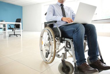İşadamı dizüstü Office ile çalışan tekerlekli sandalyede