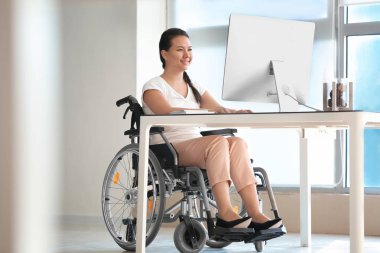 Bilgisayar Office ile çalışan tekerlekli sandalyede Asyalı kadın