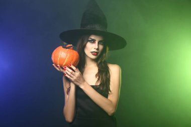 Cadı olarak Cadılar Bayramı için renk arka plan üzerinde giymiş kadın güzel