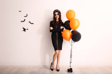 Halloween ışık yakınındaki duvara dekore için güzel bir kadın giyinmiş