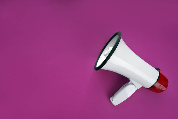 Megaphone on color background