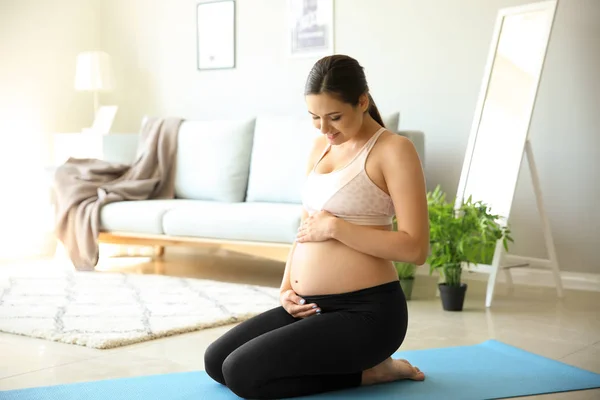 Evde Yoga Mat Üzerinde Oturan Genç Hamile Kadın — Stok fotoğraf