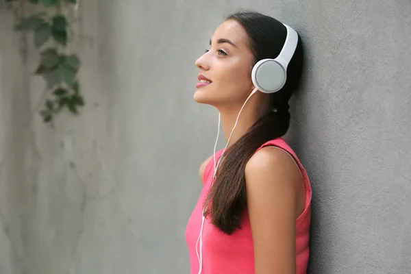 Beautiful Young Woman Listening Music Grey Wall Outdoors — Stock Photo, Image