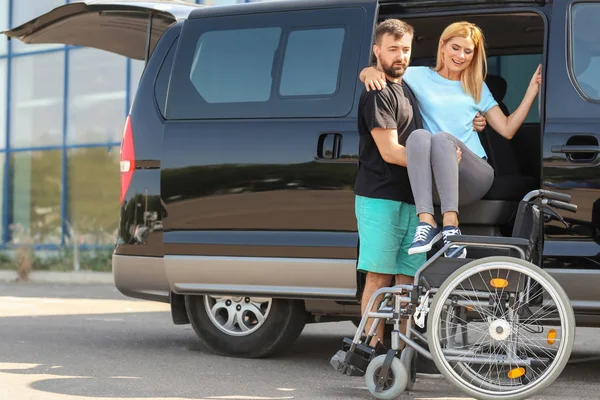 Homem Ajudando Mulher Deficiente Sentar Cadeira Rodas — Fotografia de Stock