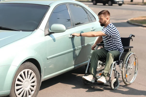 坐轮椅的人试图打开他的车 — 图库照片