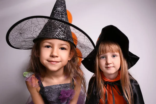 Lindas Niñas Vestidas Como Brujas Para Halloween Contra Pared Luz — Foto de Stock