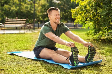 Sportif genç adam dışarıda antrenman yapıyor.