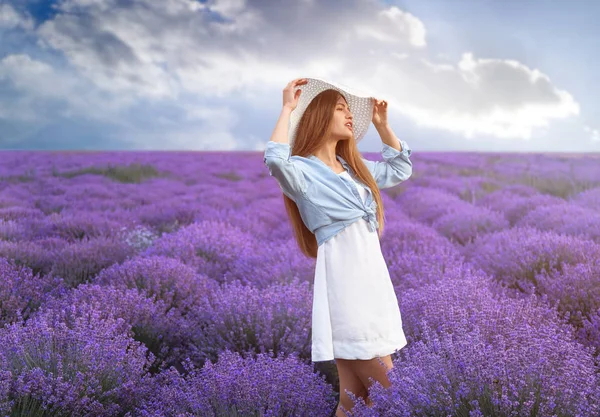 Beautiful young woman in lavender field on summer day