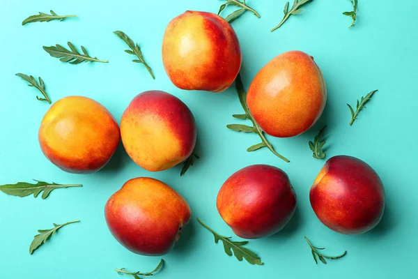 Composition with ripe peaches on color background, top view