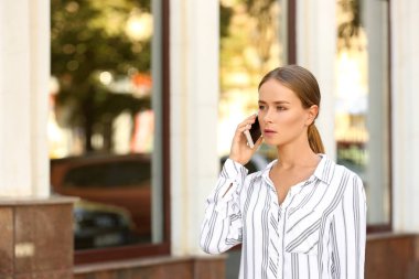 Cep telefonu açık havada tarafından konuşan genç iş kadını