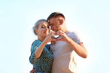 Sevimli Genç çift kendi elleriyle açık havada kalp yapma