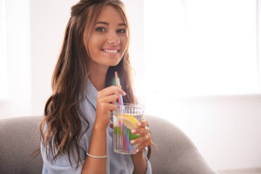 Evde limonata içen genç bir kadın.