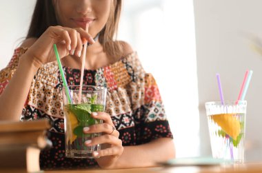 Evde limonata içen genç bir kadın.