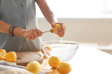 Genç kadın, evde taze limonata hazırlanıyor