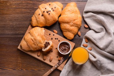 Çikolatalı hamur ve bardak portakal suyu ahşap masa üzerinde lezzetli ay çöreği