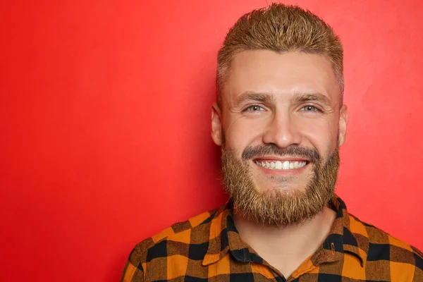 Portrait of handsome man with dyed hair and beard on color background