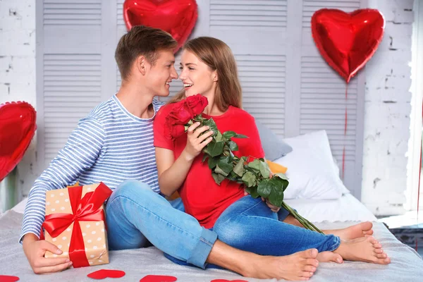 Feliz Pareja Joven Con Rosas Rojas Caja Regalo Sentada Cama —  Fotos de Stock