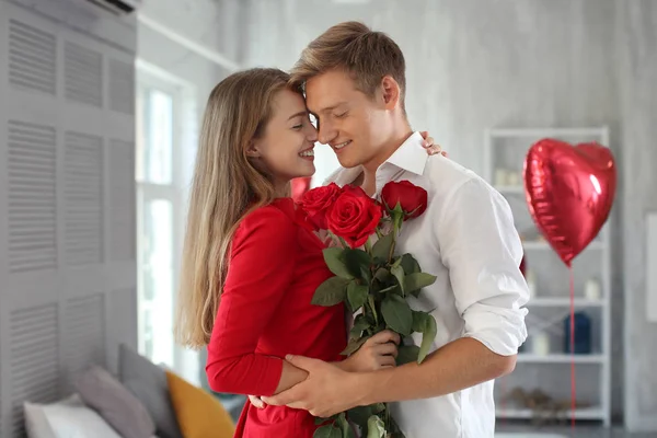 Happy Νεαρό Ζευγάρι Κόκκινα Τριαντάφυλλα Αγκάλιασμα Στο Σπίτι — Φωτογραφία Αρχείου
