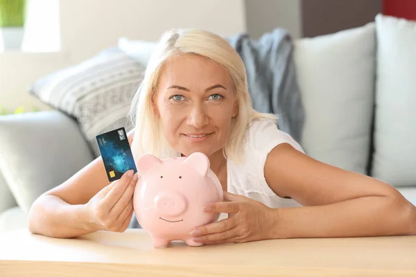 Piggy Banka Kredi Kartı Evde Olgun Kadın — Stok fotoğraf