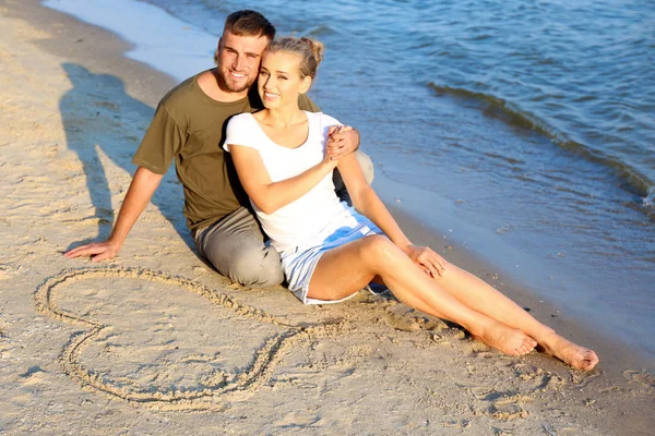 Linda Pareja Joven Sentada Cerca Del Corazón Dibujado Arena Playa — Foto de Stock