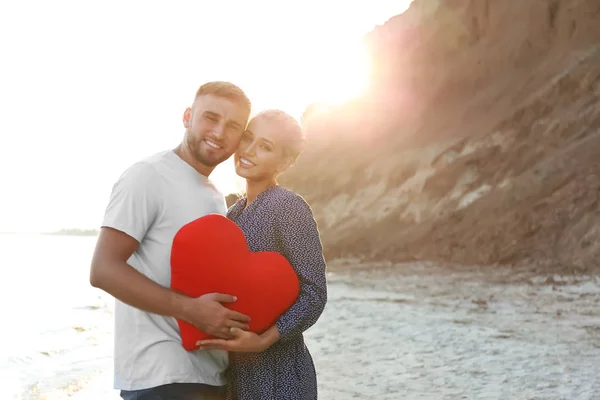 可爱的年轻夫妇与红色的心在海岸边 — 图库照片