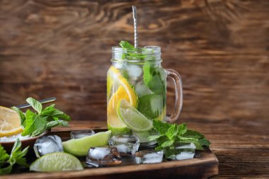 Mason kavanoza ahşap masa üzerinde taze mojito ile