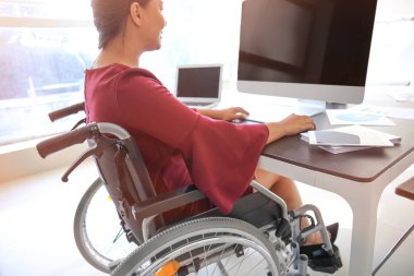 Bilgisayar Office ile çalışan tekerlekli sandalyede Asyalı kadın