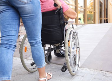 Açık havada tekerlekli sandalyede üst düzey Bayan yardımcı kadın