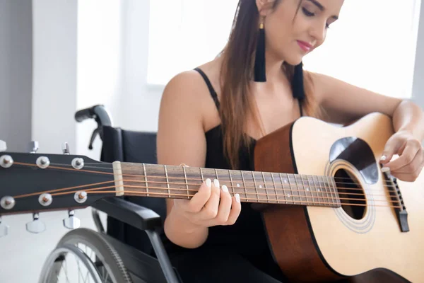 年轻的女音乐家在轮椅弹吉他 — 图库照片